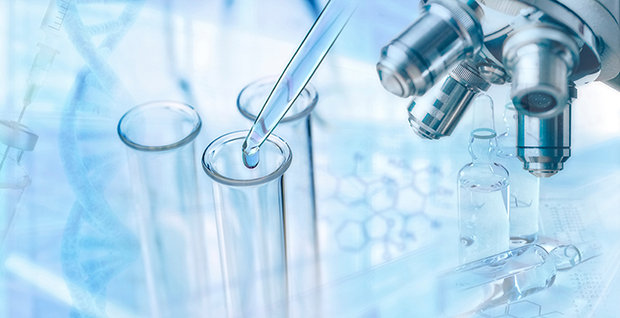 Pipette dropping liquid into three test tubes with a microscope on the side.