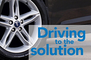 Closeup of tire on a shiny black car overlayed with blog title Driving to the Solution.