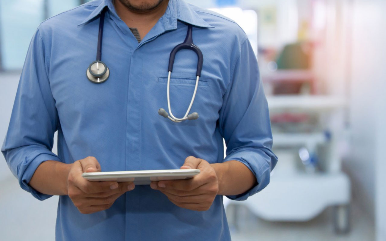 A doctor checking a tablet.