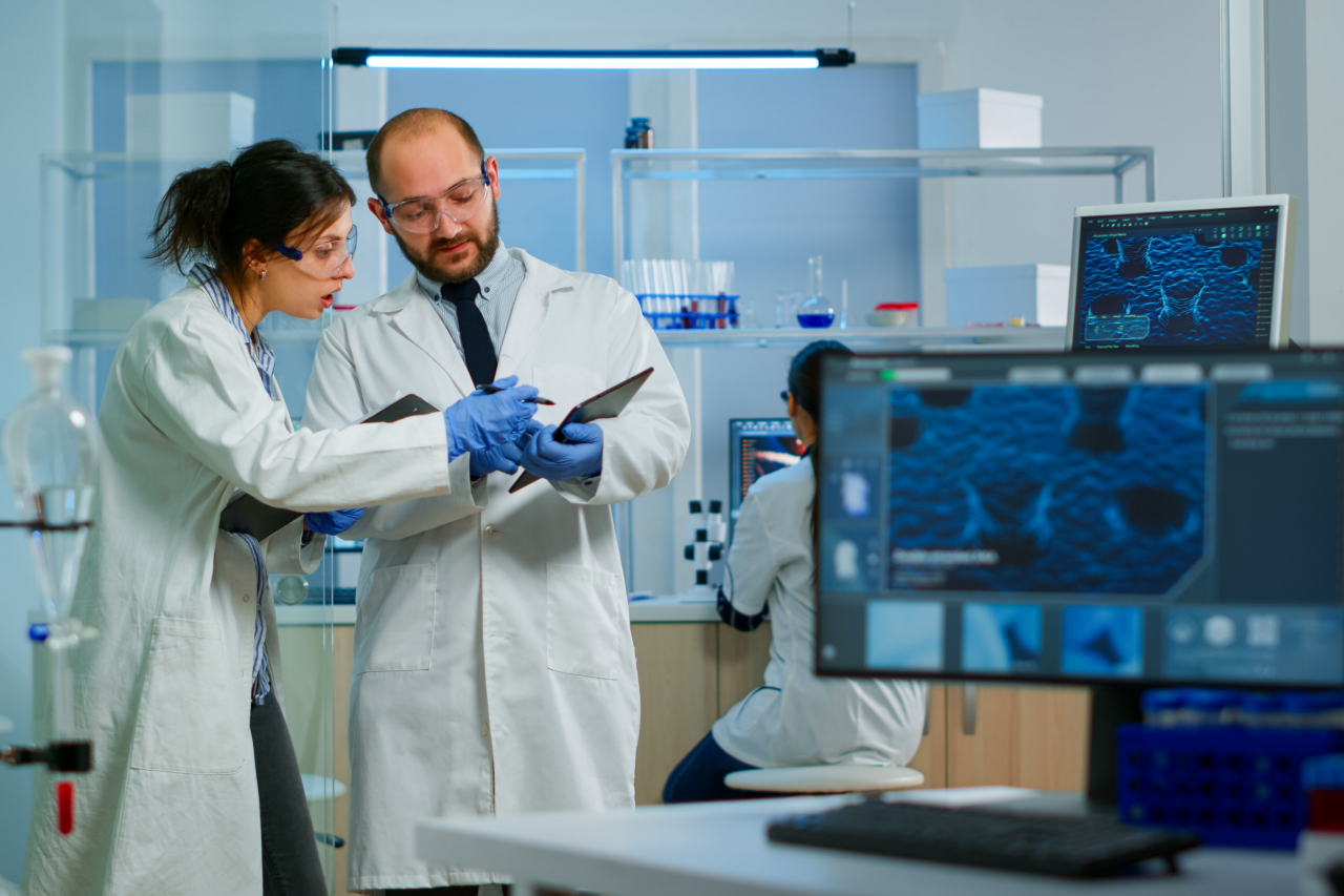 现代医学研究实验室：两位科学家正在工作，使用数字平板电脑，分析测试并交谈。先进的医药科学实验室，用于医学和生物技术开发。